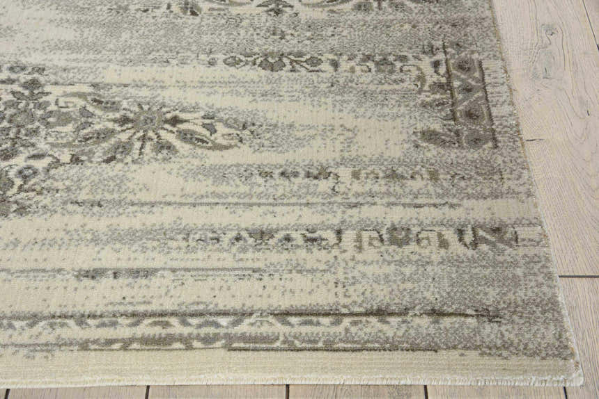 Close up of Nourison Luminance Bone Vintage Area Rug showing beige, gray, and floral pattern. Handmade rug texture.