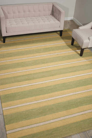Living room with a pink sofa and Barclay Butera Oxford Chesapeake rug in green, gold, and cream stripes.
