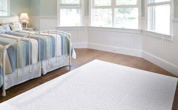 Coastal bedroom with a Feizy Saphir Mira white rug featuring a geometric chevron pattern on hardwood floors. Roomscene-Rectangle