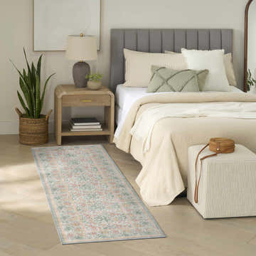 Bedroom scene with a Nourison Botanical Green Multicolor rug, wood floors, neutral bedding, and a farmhouse style.