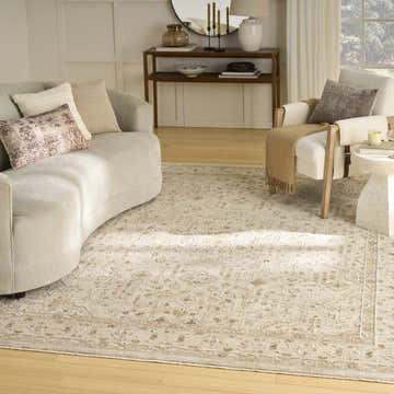Living room with curved sofa and Nourison Retreat Beige Vintage Indoor Area Rug.