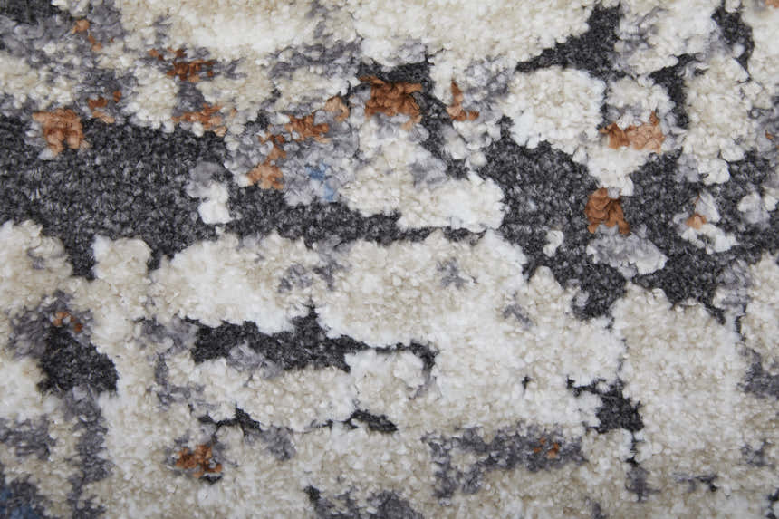 Close-up of the Feizy Gilmore rug, showcasing its ivory, gray, and blue abstract pattern and textured, plush pile. Texture