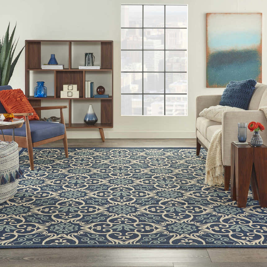 Living room scene with a Nourison Caribbean Navy Contemporary Area Rug, blue chair, and modern decor.