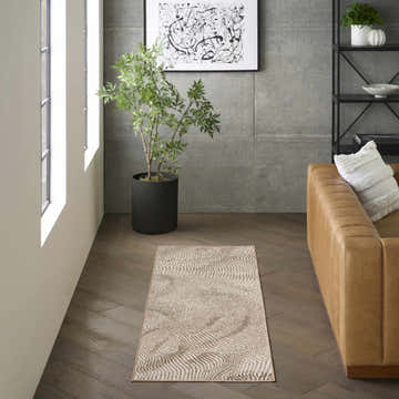 Modern living room with a beige leather sofa and DKNY Central Park West Beige Brown rug.