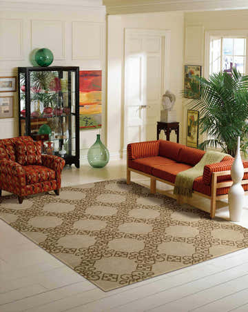 Living room scene with an almond-colored Nourison Ambrose area rug, orange sofa, patterned chair, and eclectic decor.