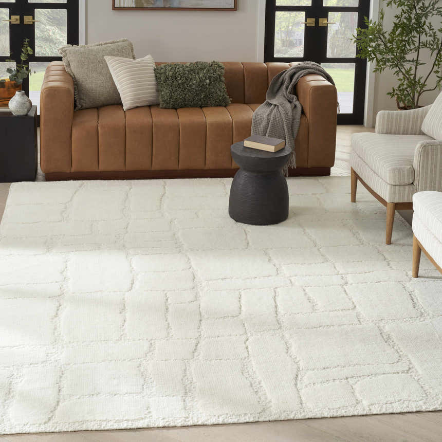 Modern living room with a chestnut leather sofa and the Nourison Blanco Ivory Area Rug.