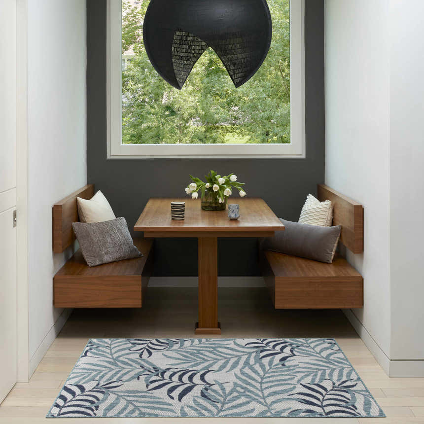 Breakfast nook with wood benches and Nourison Garden Oasis Blue Tropical Area Rug.