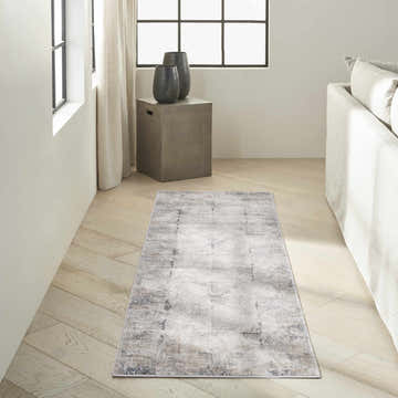 Modern living room with a Calvin Klein CK022 Infinity ivory and grey runner rug on light wood floors.