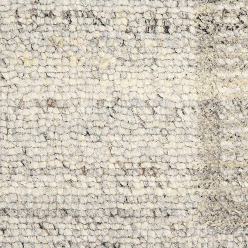 Close-up of the Calvin Klein CK082 Ridge rug. Grey and ivory wool rug with a textured, handmade weave.