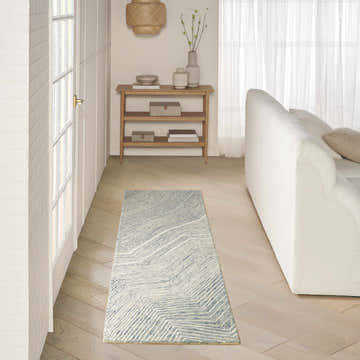 Hallway scene with DKNY Pure Angles Ivory Blue runner rug, white sofa, and light wood console table.