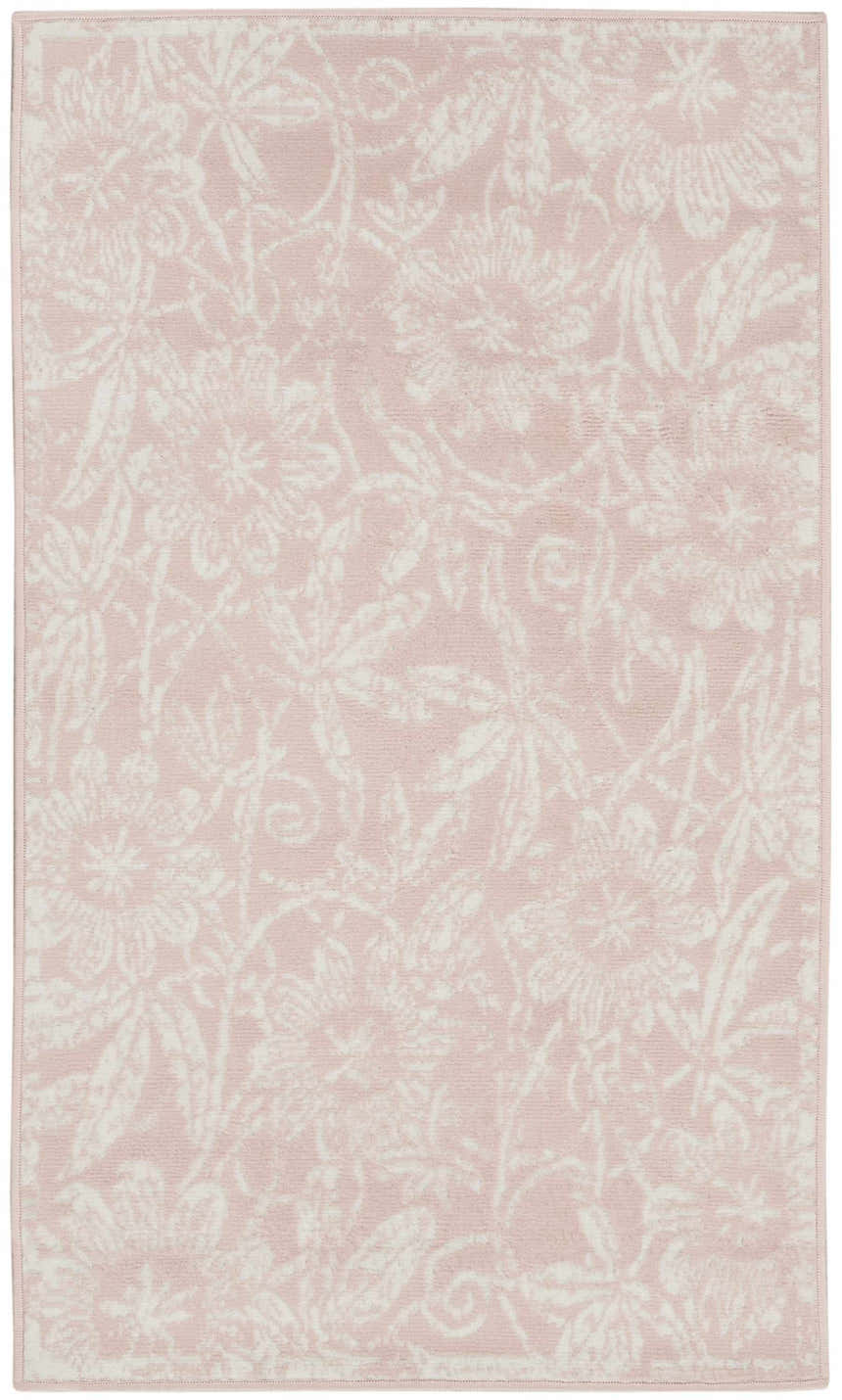 Close-up of the Nourison Whimsicle Pink Farmhouse rug featuring a delicate white floral pattern on a soft pink background.