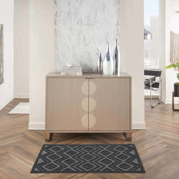 Modern entryway with a Nourison Versatile Charcoal Black rug, wood floors, and a taupe cabinet with silver accents.