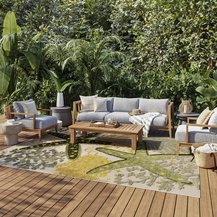 Outdoor patio scene with gray furniture and Nourison Aloha Green Yellow Outdoor Area Rug.