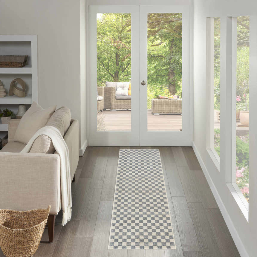 Living room scene with Nourison Serenity Home Ivory Blue runner rug, neutral sofa, and view to outdoor patio.