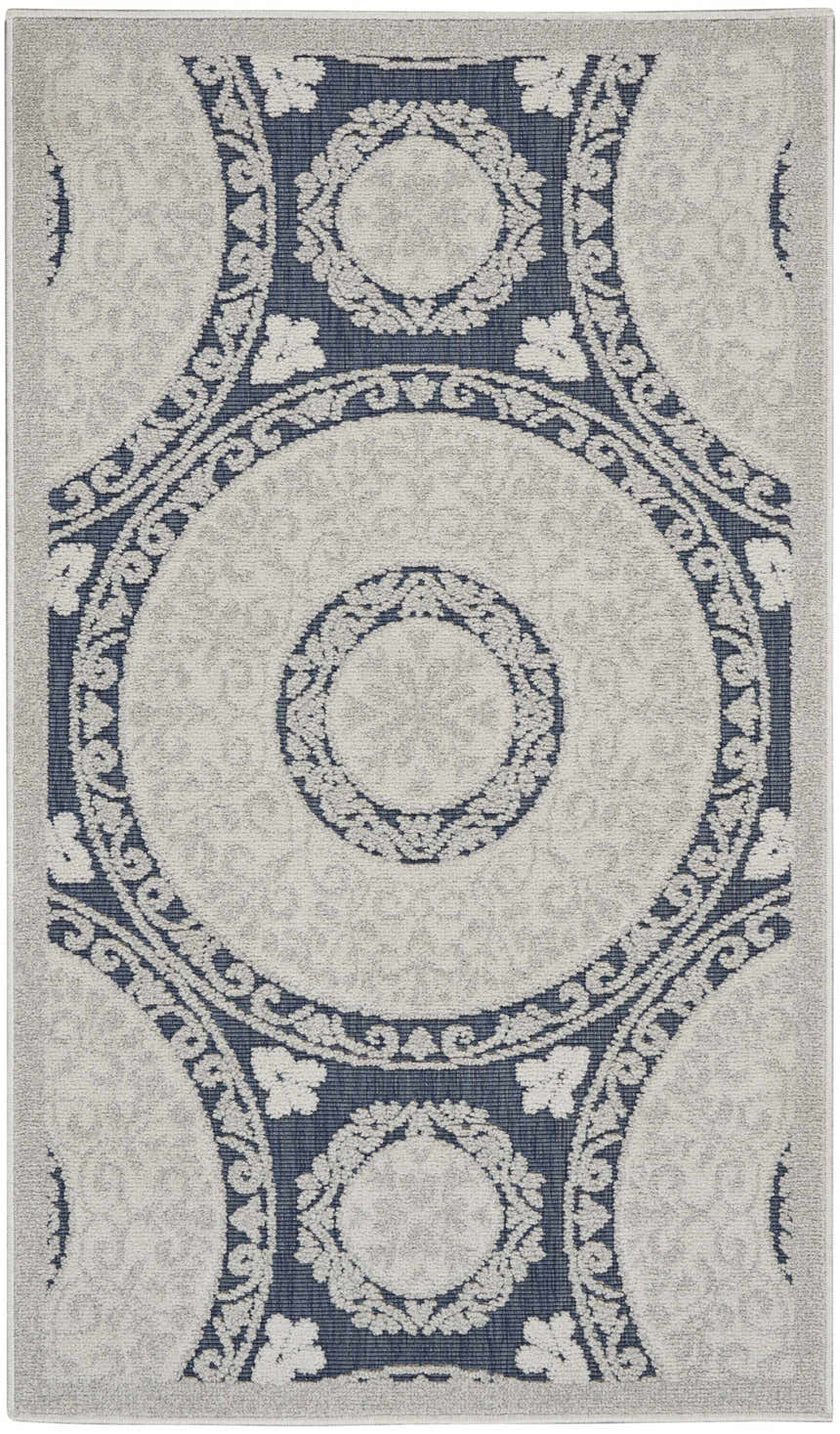 Close-up of Nourison Key Largo Blue Contemporary Area Rug. Features a circular, floral pattern in light blue and navy.