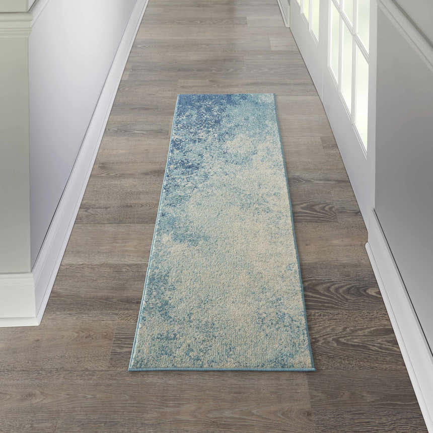 Hallway scene with a Nourison Passion Navy Light Blue runner rug on wood floor, white walls and trim.