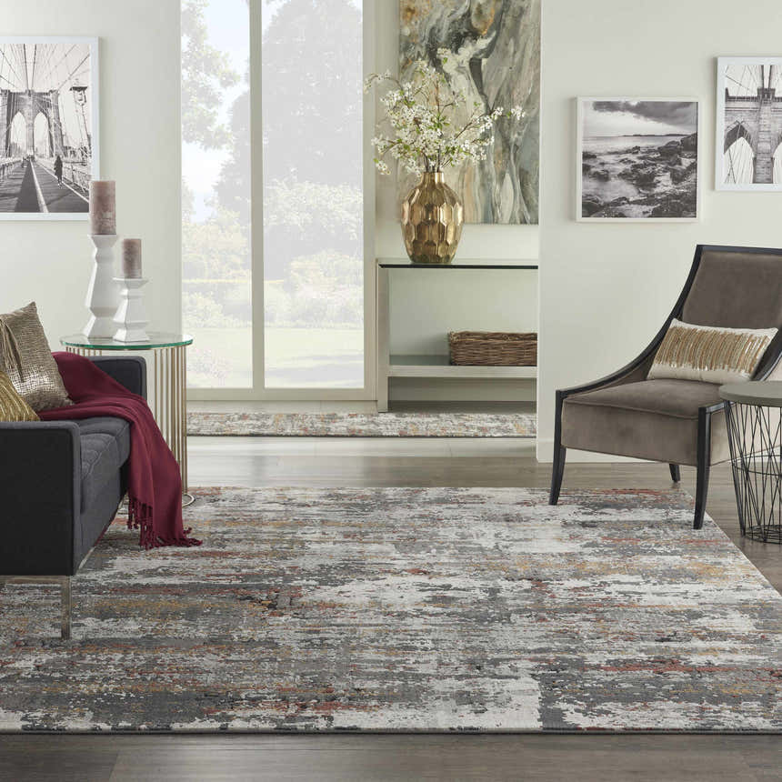 Living room scene with a Nourison Tangra Grey Multicolor rug, gray sofa, and modern art.