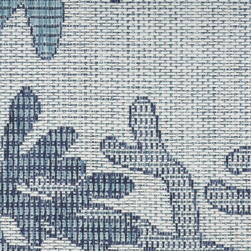 Close-up of Nourison Garden Oasis Blue Coastal Area Rug. Woven texture with light and dark blue floral pattern.