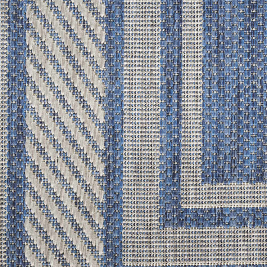 Close-up of the Nourison Horizon Denim Area Rug. Shows blue and white geometric pattern and woven texture.