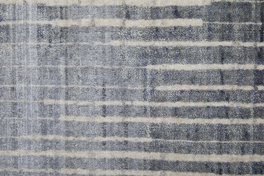 Close-up of Feizy Eastfield rug. Modern abstract distressed grid pattern in blue, ivory, and gray. Hand woven wool and viscose. Texture