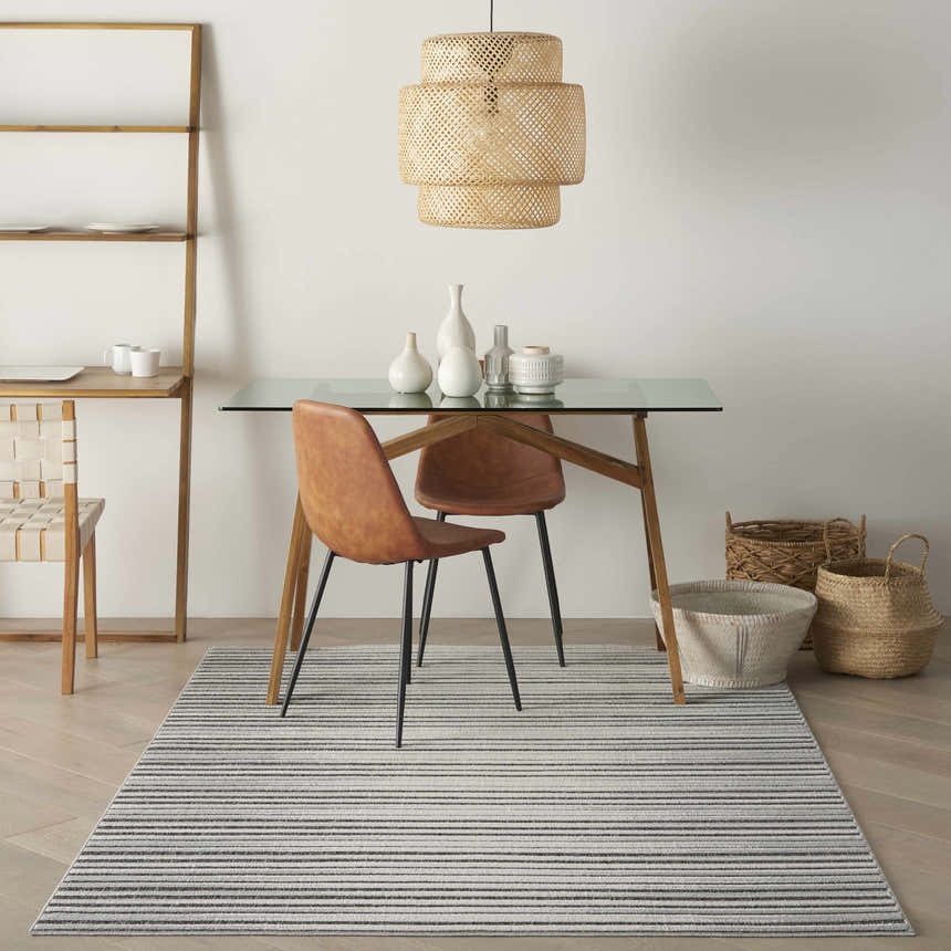 Dining room with glass table and Nourison Key Largo Dark Grey rug. Contemporary style.