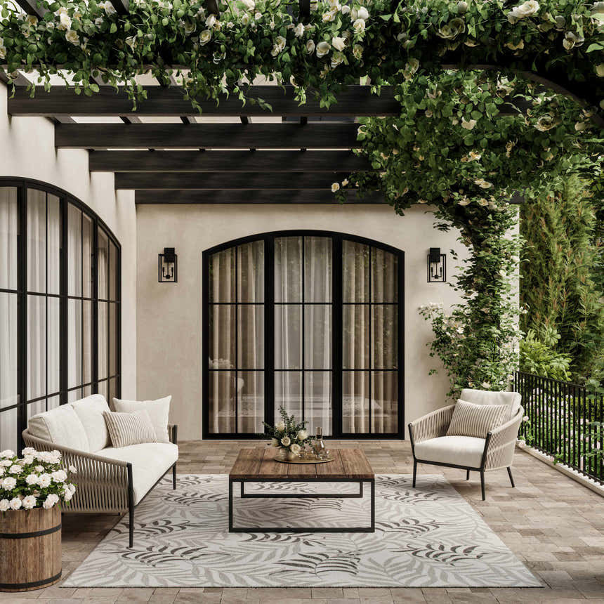 Outdoor patio with white furniture and Nourison Garden Oasis Grey Tropical Area Rug.