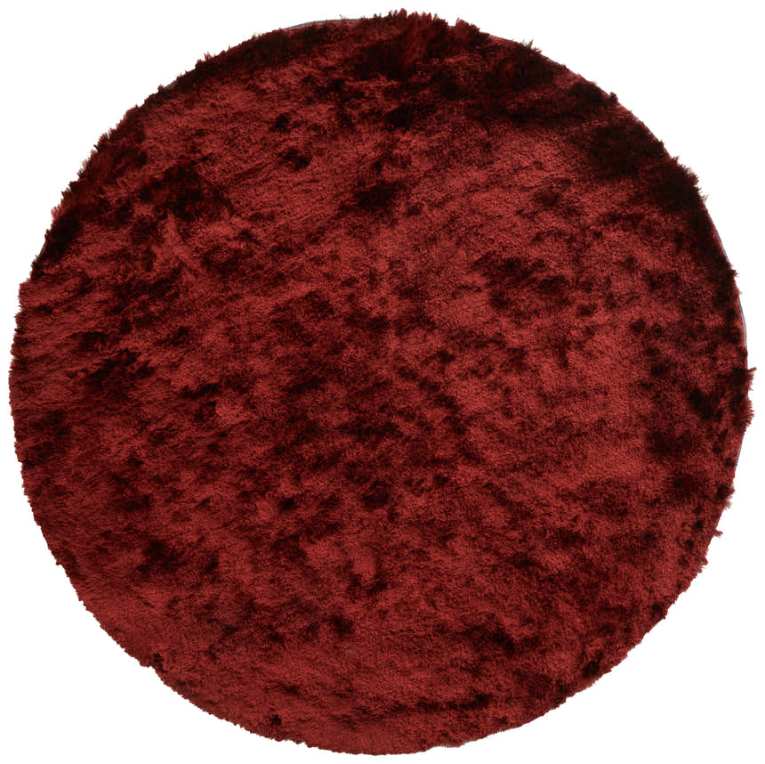Close-up of a round, solid red Feizy Indochine rug. The hand-tufted rug has a soft, plush texture. Design-Round