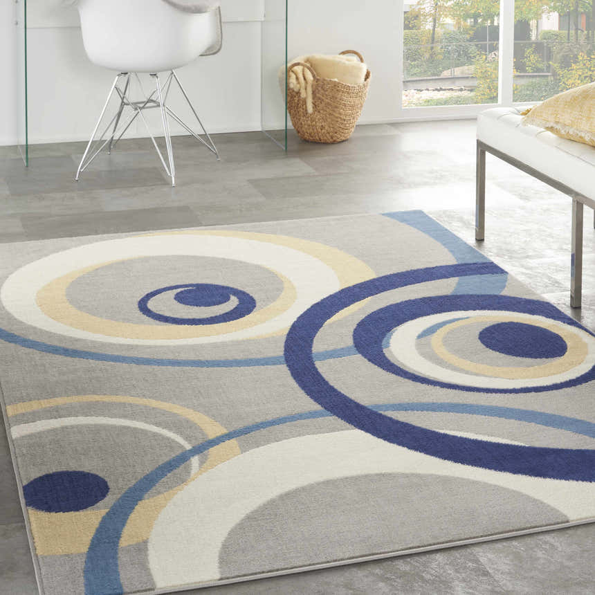Modern living room with a grey Nourison Grafix rug featuring blue, yellow, and white circle patterns.