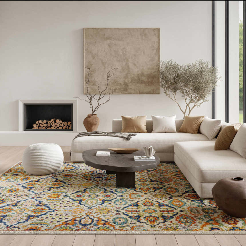 Living room scene with a Nourison Allur Ivory Multicolor rug, sectional sofa, fireplace, and neutral decor.