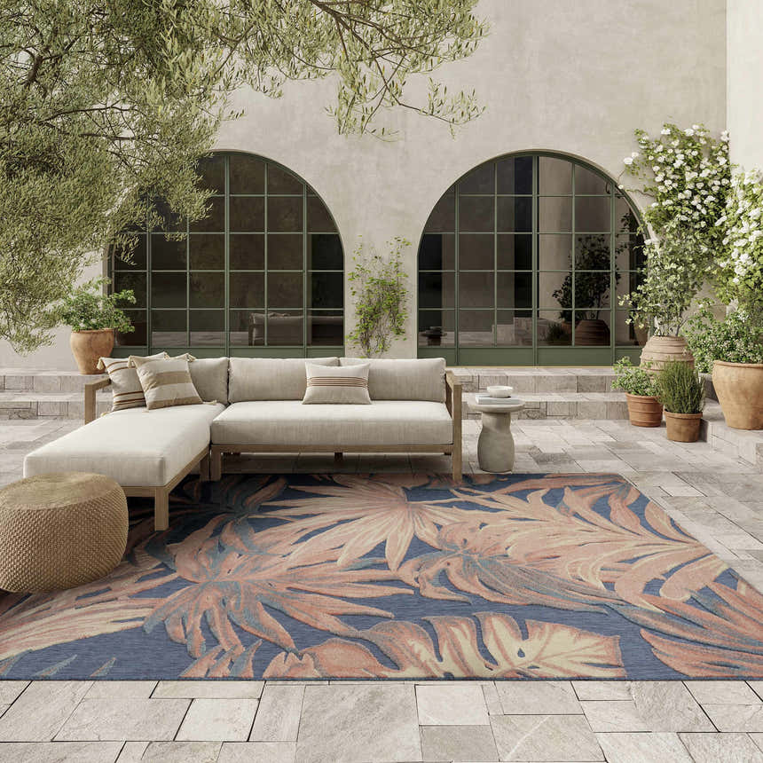 Outdoor patio scene with a sectional sofa and the Nourison Aloha Blue Rose rug.