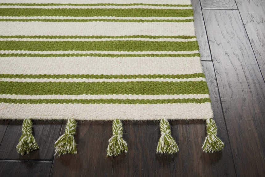 Close-up of the Nourison Rio Vista Ivory/Green rug showing the stripe pattern and wool tassels on dark wood floors.