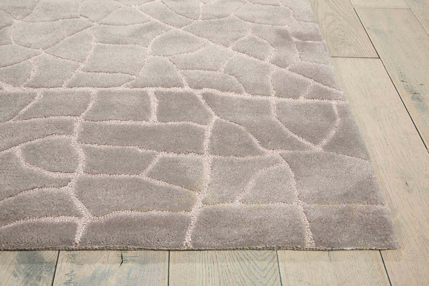Close up of the gray Nourison Escalade Granite area rug featuring a geometric, cobblestone-like pattern and soft texture.