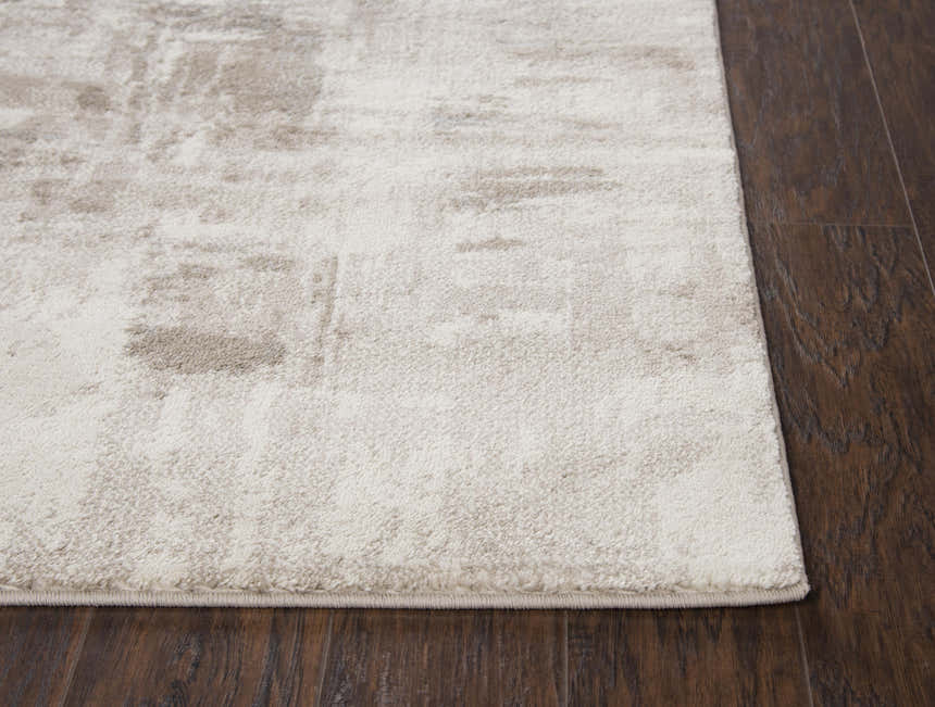 Close-up of the Rizzy EN7258 area rug. Beige and light gray contemporary rug with a subtle abstract pattern. Corner