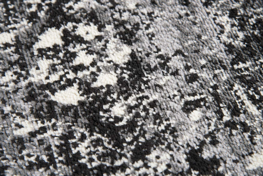 Close-up of Rizzy EN7272 area rug showing black, ivory, and light gray abstract pattern and soft, textured polypropylene fibers. Texture