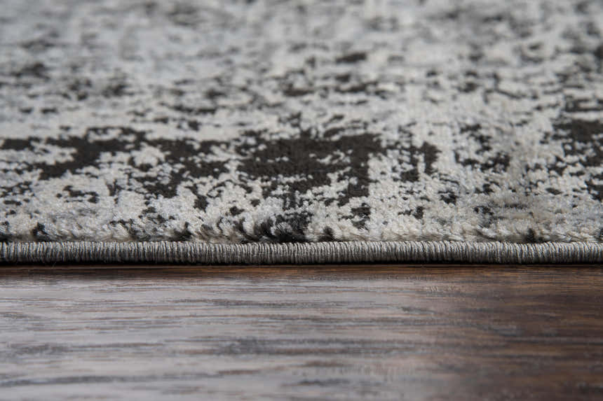 Close-up of Rizzy EN7272 area rug showing black and light gray abstract pattern and polypropylene texture. Pile