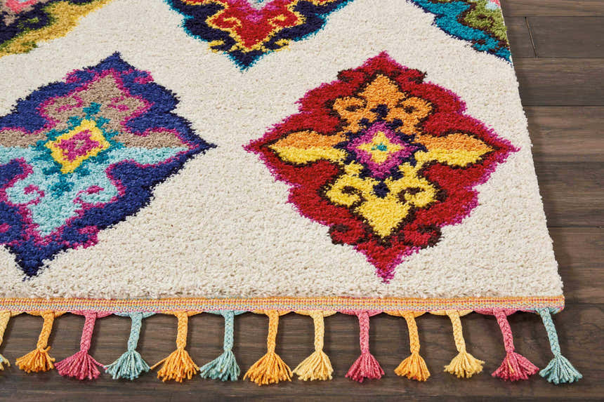 Close-up of Nourison Nomad Ivory Multicolor Floral rug with colorful diamond pattern and decorative tassels.