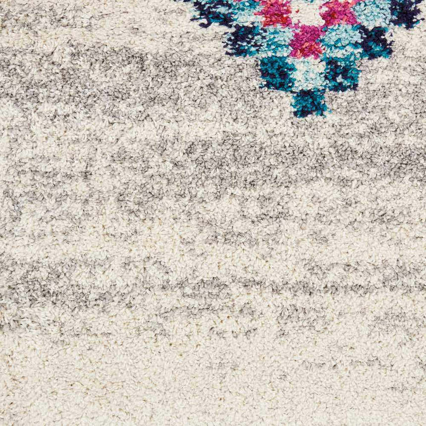 Close-up of the Nourison Nomad Cream Grey Tribal Rug, showing texture and tribal pattern with pink and teal accents.
