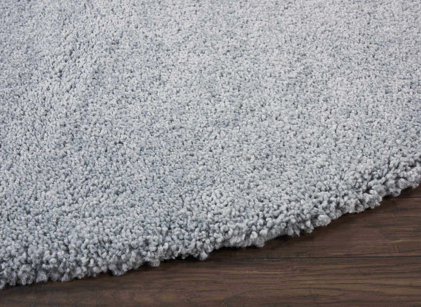 Close-up of the plush texture and slate taupe color of the Nourison Malibu Shag rug on dark wood flooring.