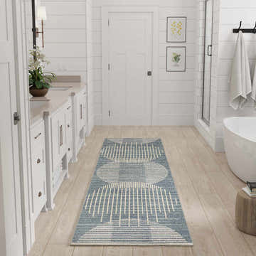 Light blue Nourison Astra rug in a white, modern bathroom with wood floors.