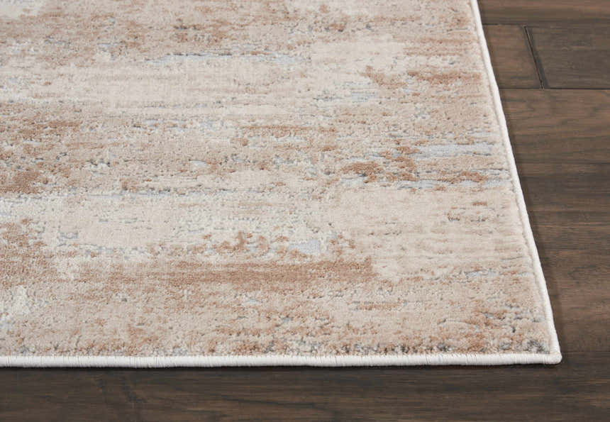 Close up of the beige Nourison Rustic Textures rug showing the subtle pattern and soft texture on a dark wood floor.