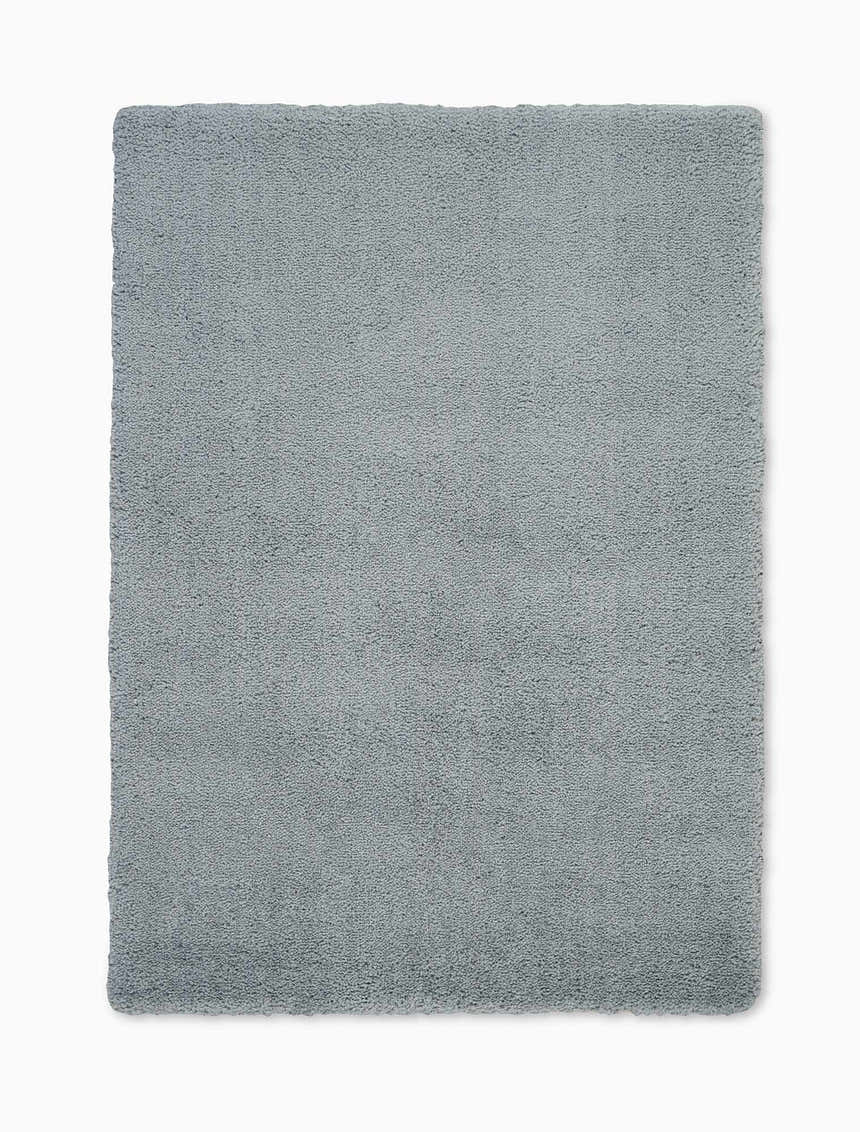 Close-up of the Calvin Klein Chicago Shag rug. The grey rug has a soft, textured, shag pile. Rectangle shape.