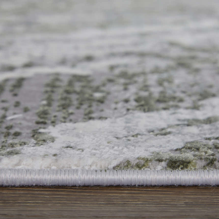 Close-up of the Feizy Cadiz rug showing its gray, green, and taupe abstract pattern and soft, textured pile. Pile
