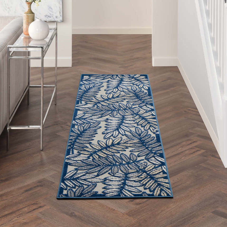 Hallway scene with Nourison Aloha Ivory Navy Tropical Area Rug runner on dark wood floor.