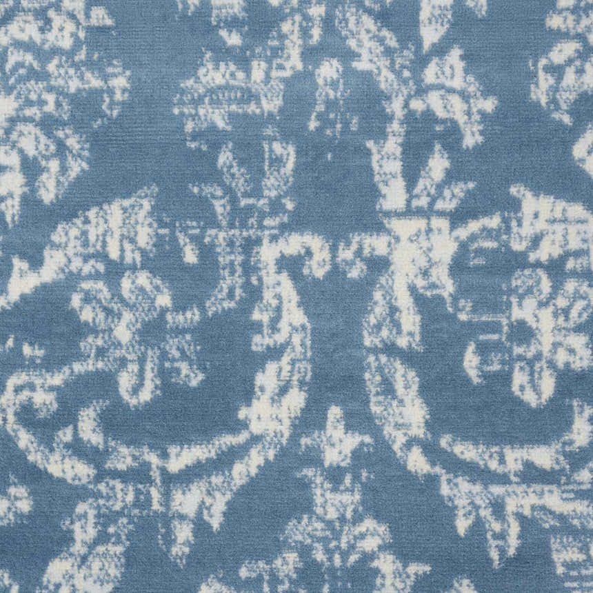 Close-up of the Nourison Jubilant Blue Vintage Indoor Area Rug, featuring a light blue and white distressed floral pattern.