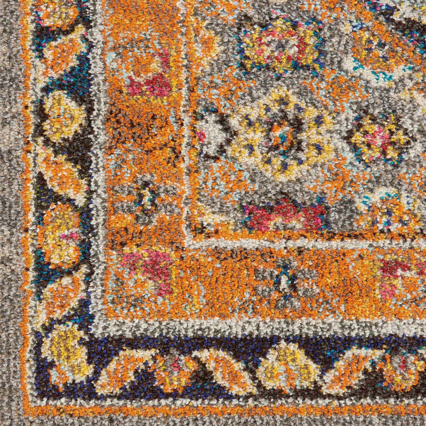Close-up of the Nourison Passionate Grey Bohemian rug, featuring orange, blue, and yellow floral accents.
