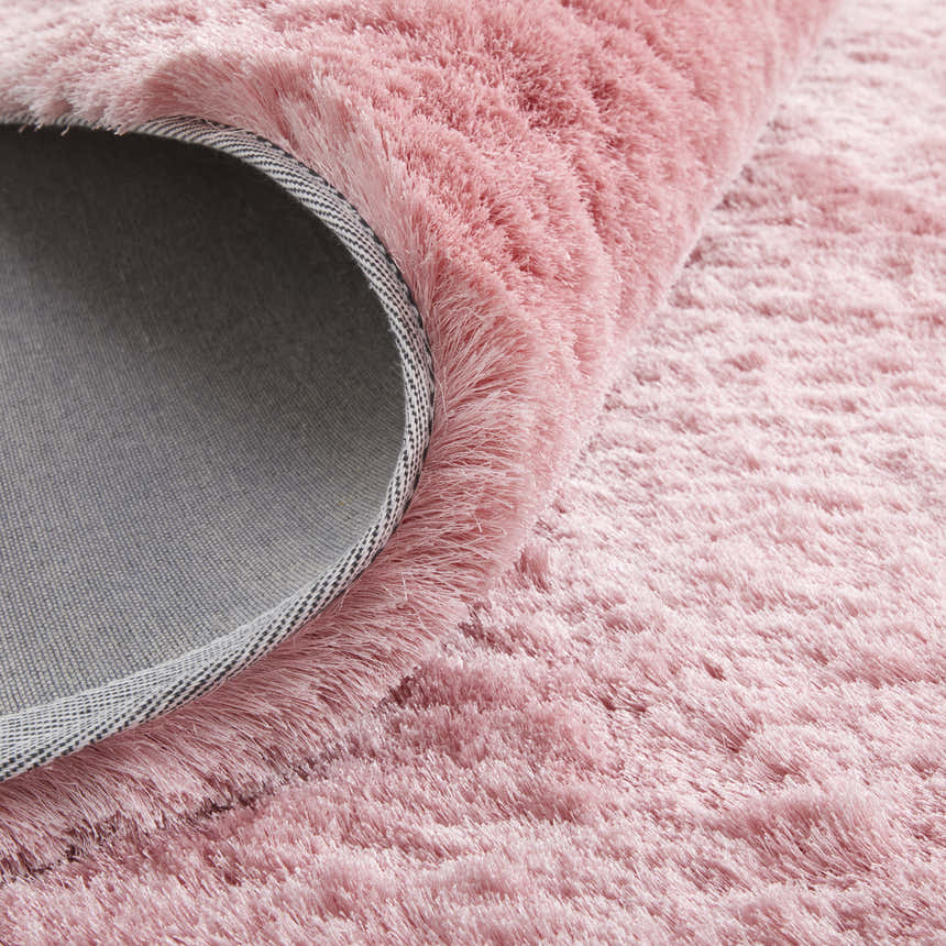 Close-up of the textured, blush pink Feizy Indochine rug, showing its soft pile and durable backing. Fold