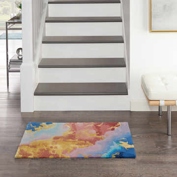 Entryway with Nourison Prismatic Multicolor rug, white stairs, and leather bench. Contemporary style.