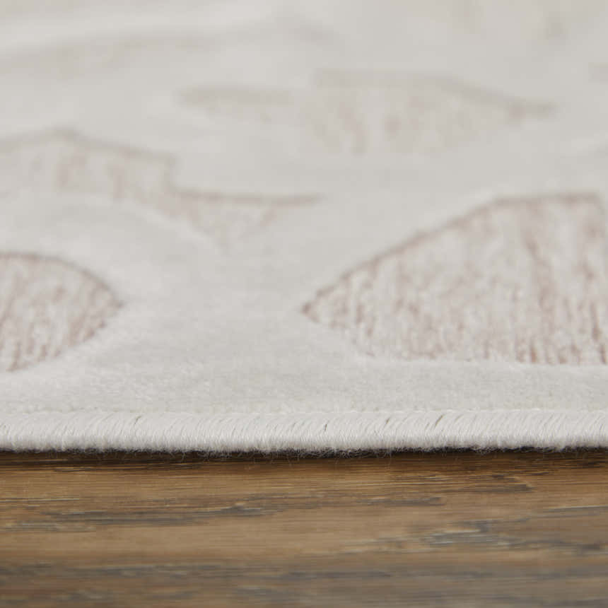 Close-up of Feizy Saphir Mira rug showing pink geometric diamonds on a white background with a soft, textured pile. Pile