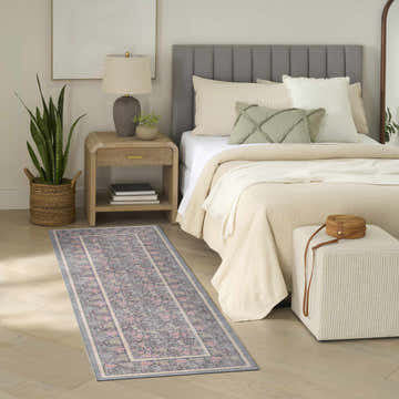 Farmhouse bedroom scene with Nourison Botanical Charcoal Multicolor runner rug, wood floors, and neutral bedding.