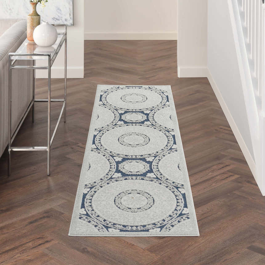 Hallway with Nourison Key Largo Blue contemporary runner rug, silver console table, and herringbone wood floors.